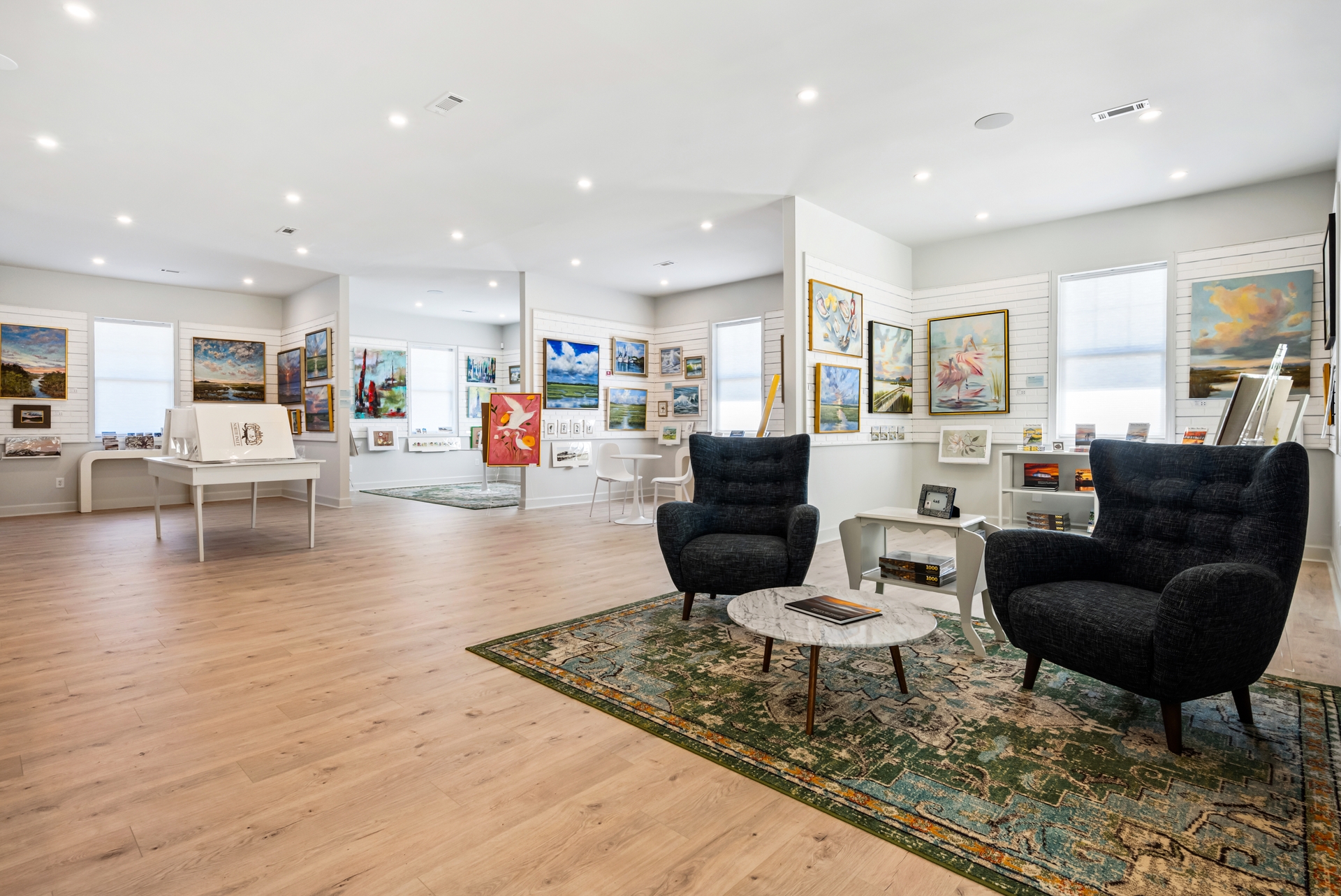 Gray Man Gallery interior with lounge chairs, framed art and wood flooring
