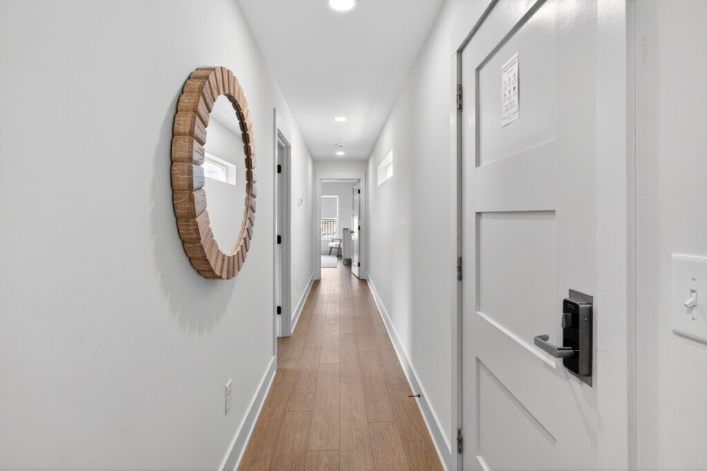 Winyah Bay Club hallway with round mirror and light wood-look plank flooring