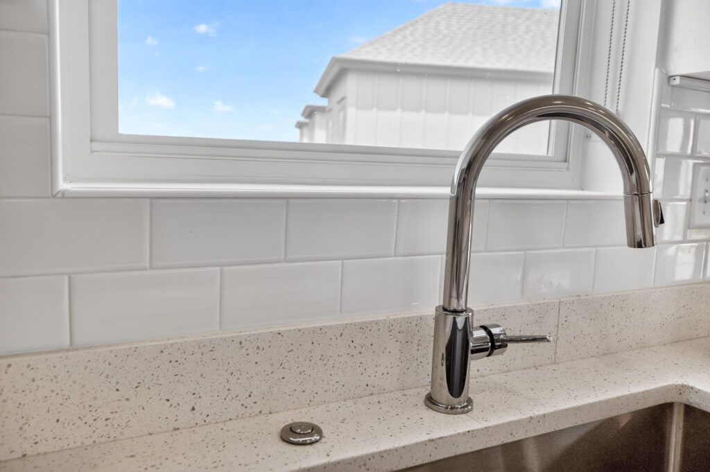 Close-up of kitchen faucet and white tile backsplash at Winyah Bay Club