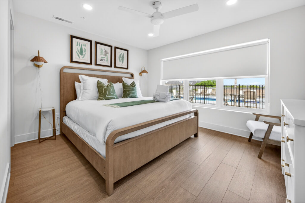 Winyah Bay Club bedroom with wood bed frame and green and teal pillows