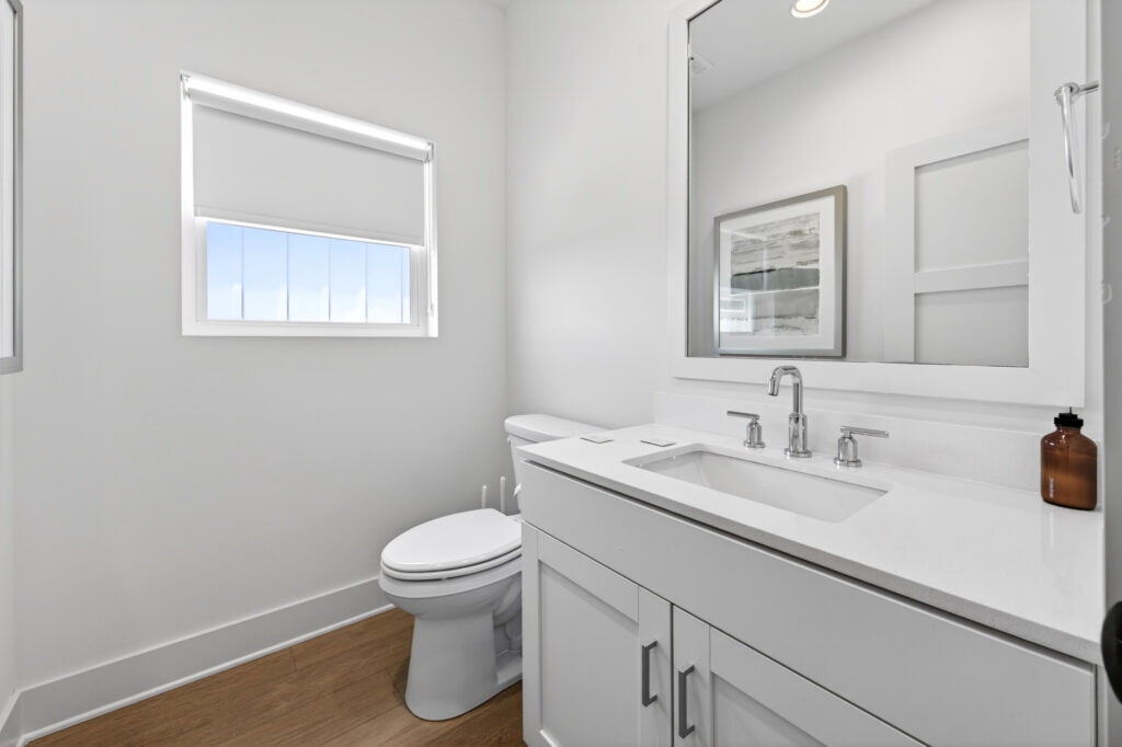 Winyah Bay Club bathroom with vanity, toilet and framed art