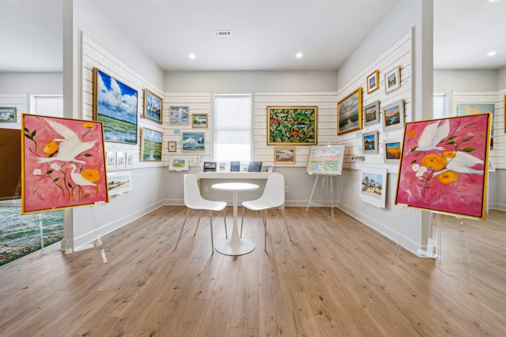 Gray Man Gallery room with gallery wall of framed art and round white tables