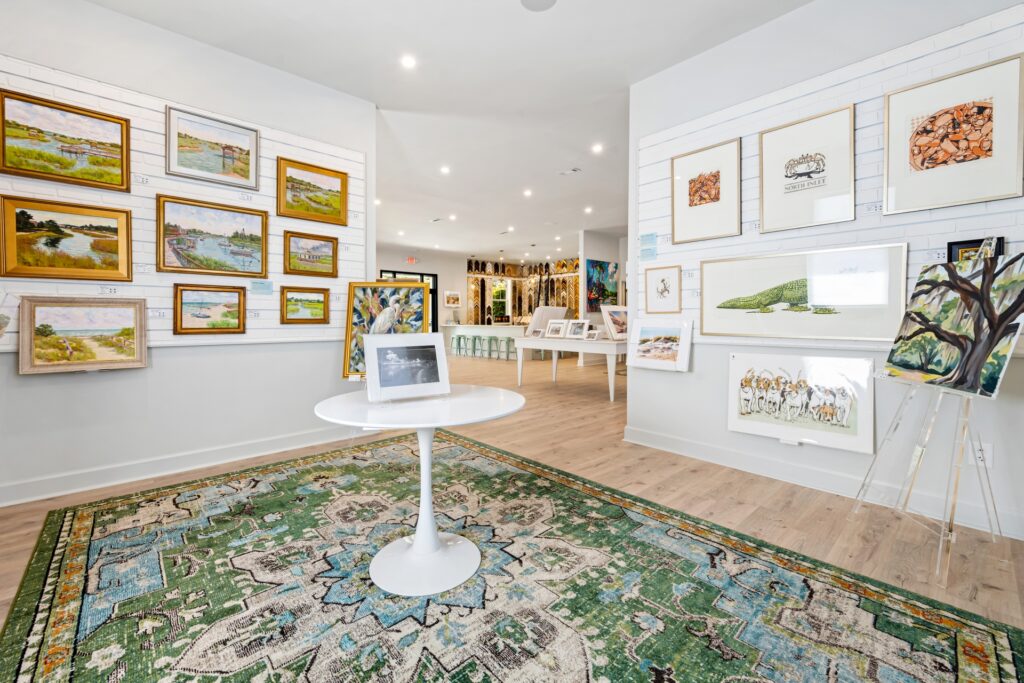 Gray Man Gallery with framed art, round white table and green patterned rug