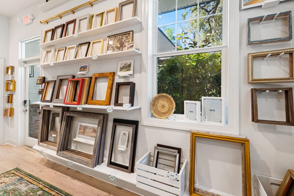 Gray Man Gallery display wall with colorful framed art and window