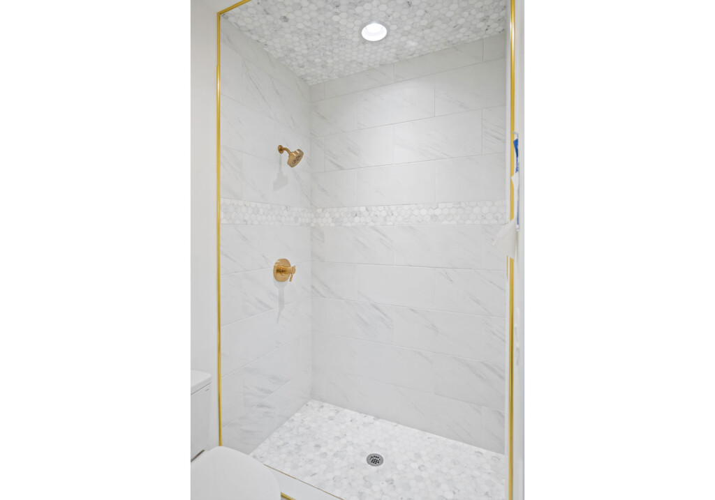Collins Meadows shower with gold trim and brass fixtures