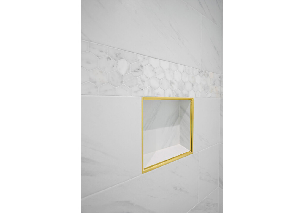 Collins Meadows shower niche with gold trim and marble-look tile