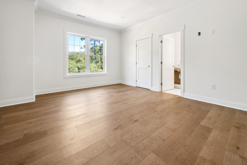 Collins Meadows empty bedroom with wood flooring and doorway