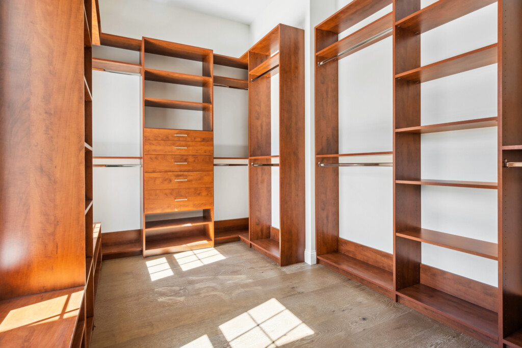 Collins Meadows walk-in closet with built-in wood shelving