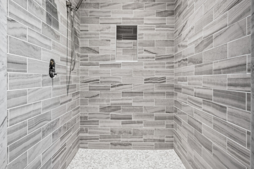 Collins Meadows shower with gray and white linear tile
