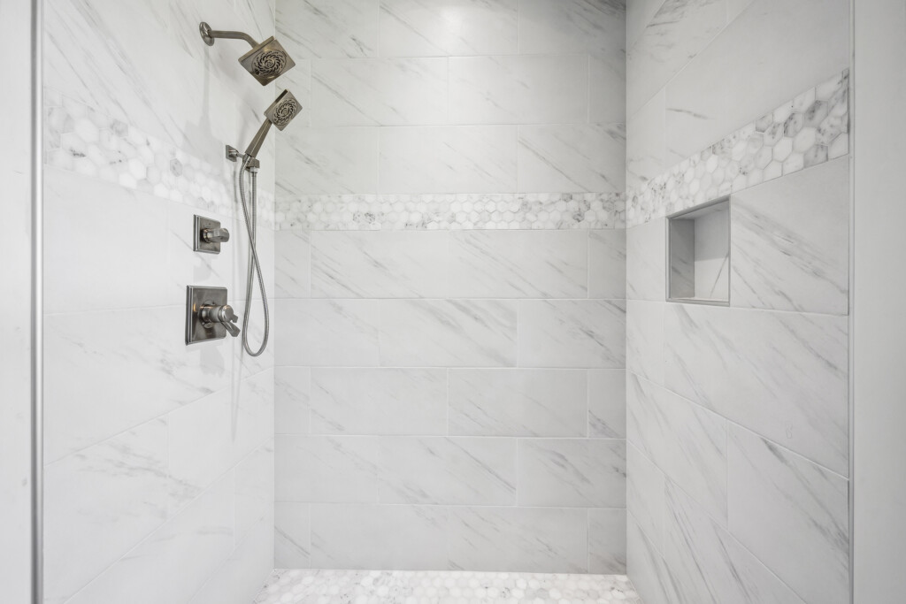 Collins Meadows shower with large-format marble-look tile, niche and shower valve