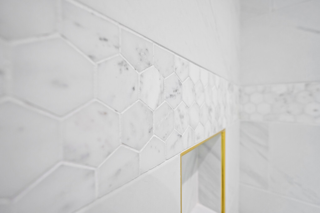 Close-up of hexagon marble-look tile and gold trim at Collins Meadows
