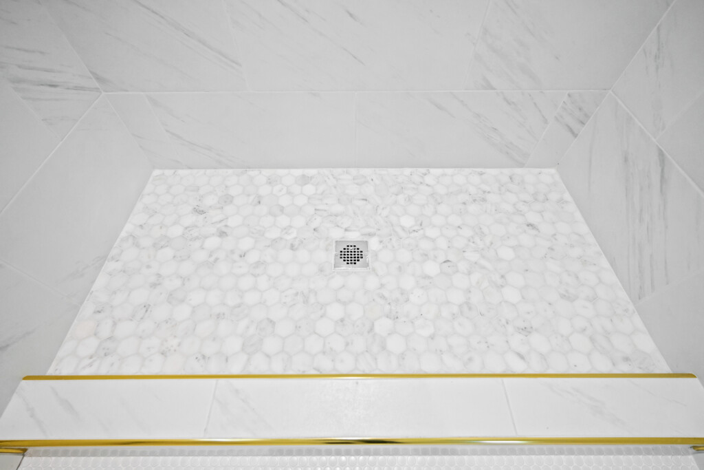 Hexagon mosaic tile shower floor with drain at Collins Meadows, tile by J&S Flooring