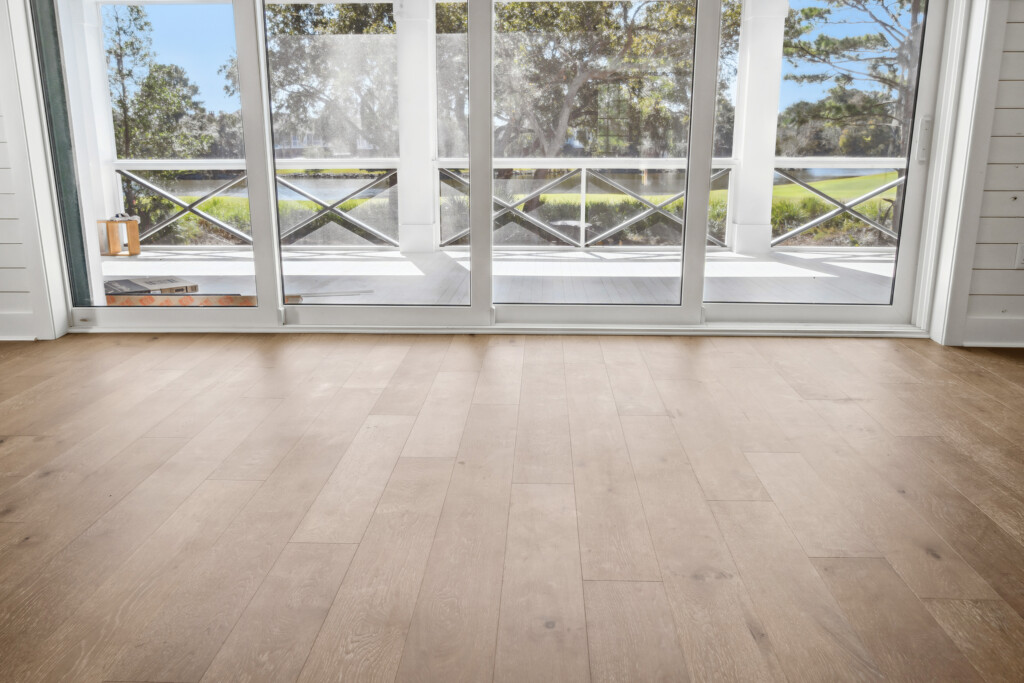 Collins Meadows living area with wood flooring and screened porch beyond