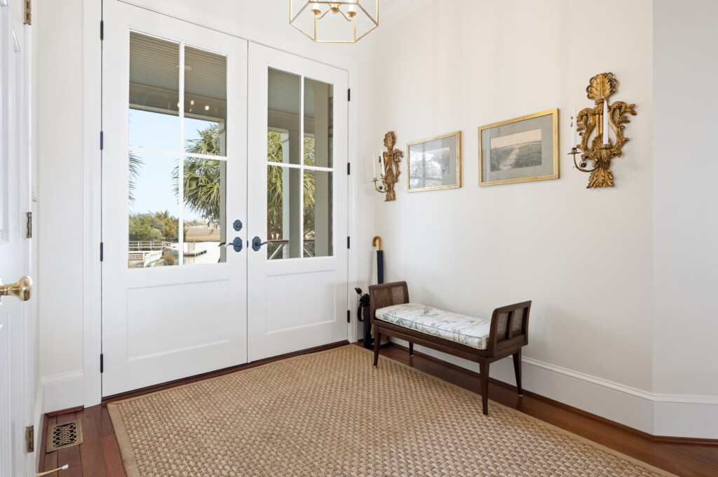 Colony Point entry sitting area with French doors, wood bench and hardwood flooring