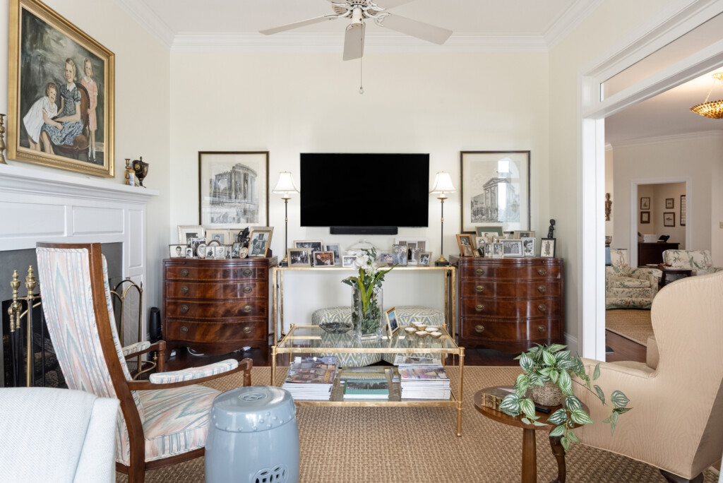 Colony Point sitting room with wall-mounted TV and antique chests
