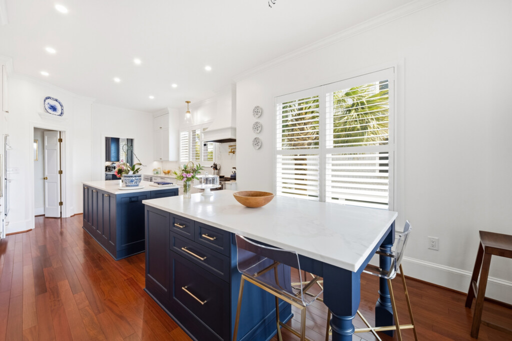 Colony Point kitchen island with navy cabinetry and brass pulls