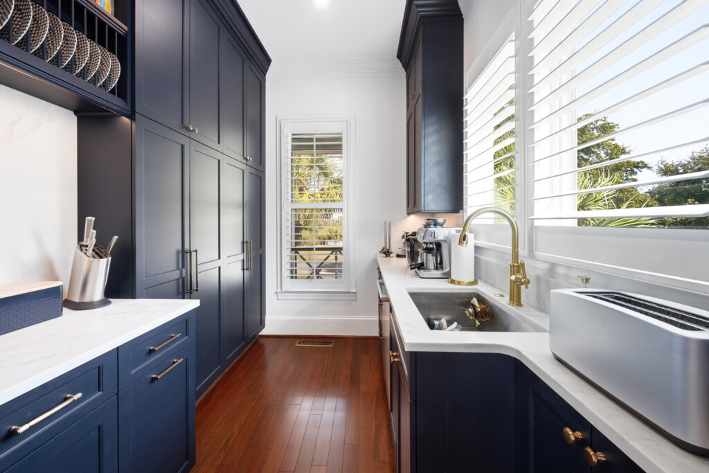 Colony Point kitchen with navy cabinets, farmhouse sink and hardwood flooring