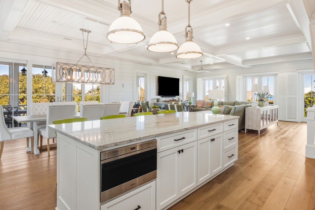 DeBordieu kitchen island with white cabinetry and open living area beyond