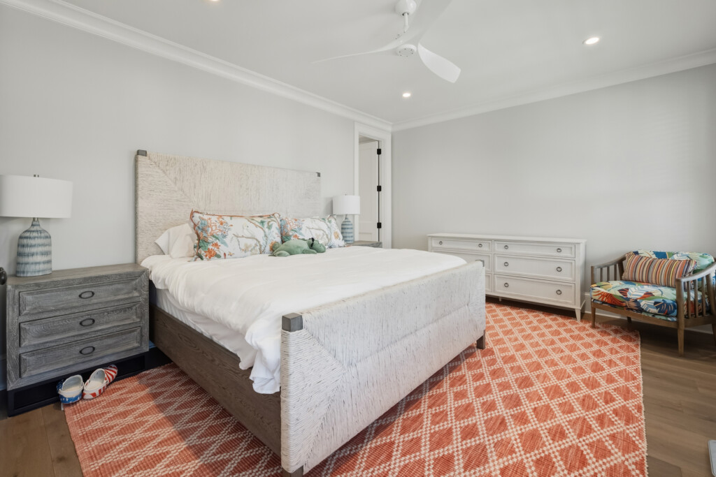 DeBordieu primary bedroom with white bed and coral rug