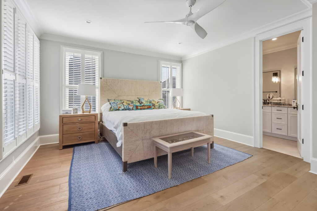 DeBordieu bedroom with upholstered bed, wood nightstands and blue area rug