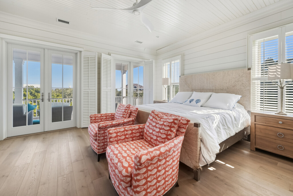 DeBordieu bedroom with red patterned chairs and balcony doors