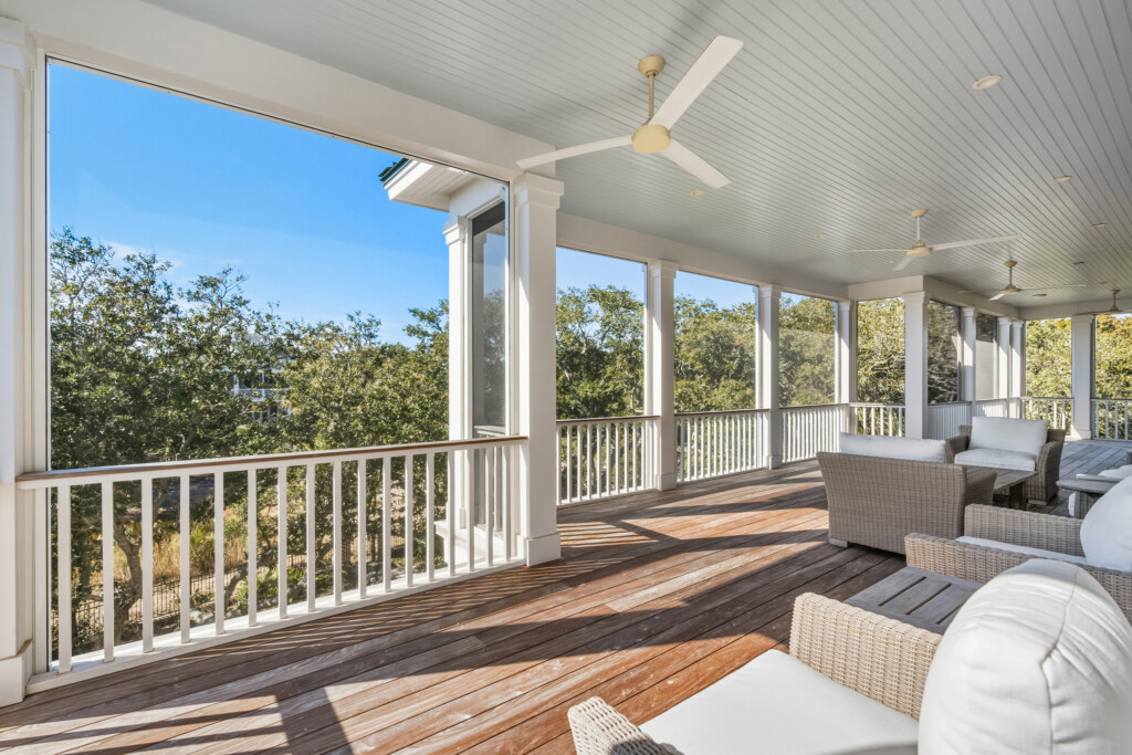 DeBordieu screened porch with white railing overlooking trees