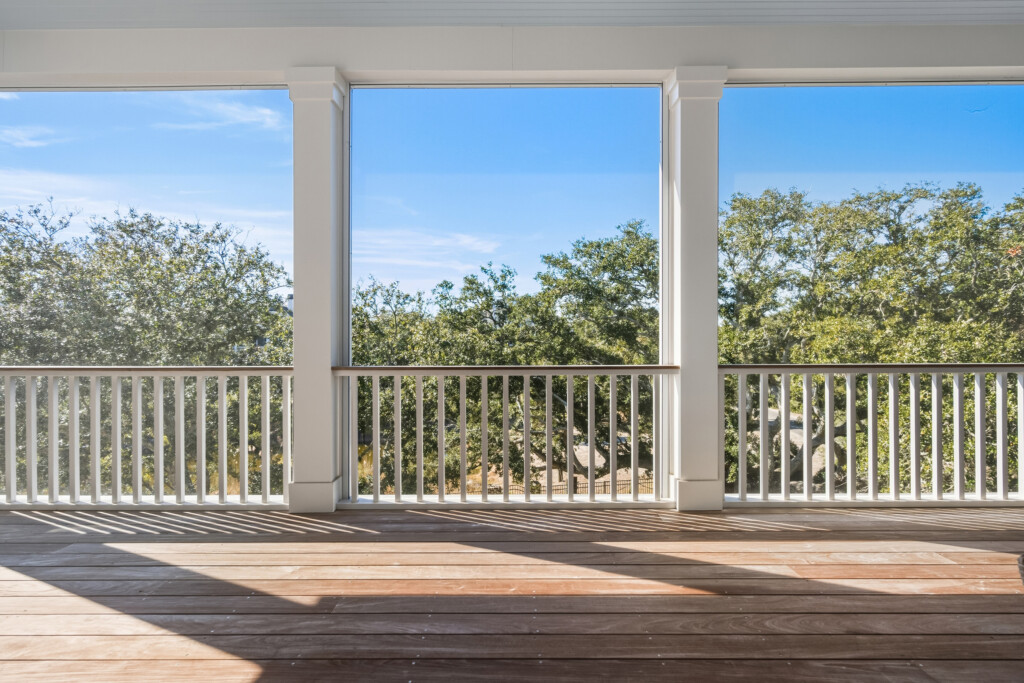 DeBordieu covered porch with white railing and tree views