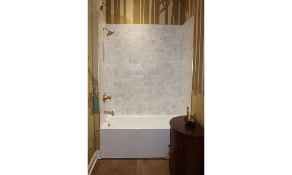 Marble-look tile tub and shower surround with brass fixtures