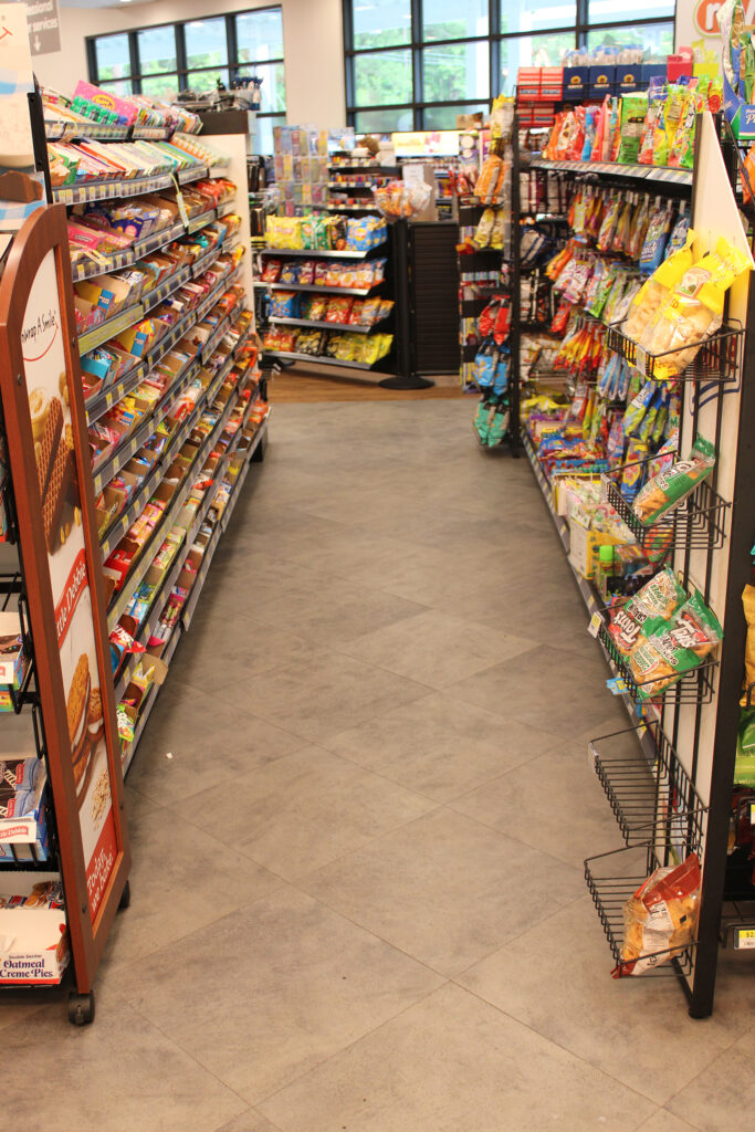 Refuel Georgetown snack aisle with gray stone-look commercial flooring
