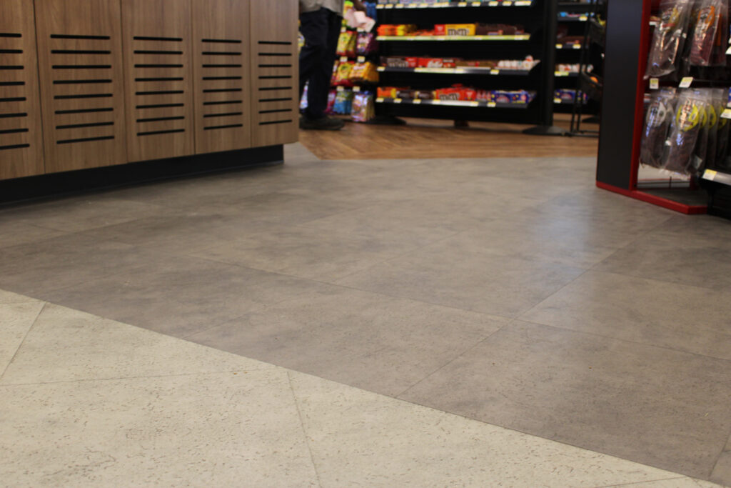 Refuel Georgetown store floor with gray stone-look flooring meeting wood-look plank