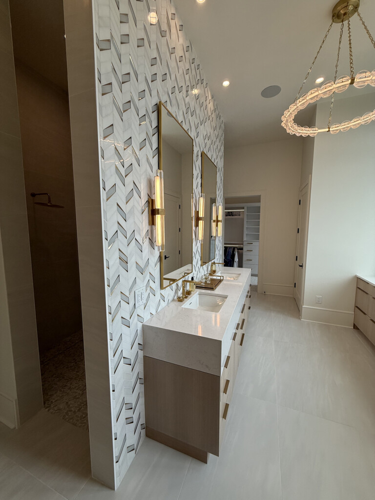 Woodward Project bathroom vanity with patterned wall tile, gold sconces and mirror
