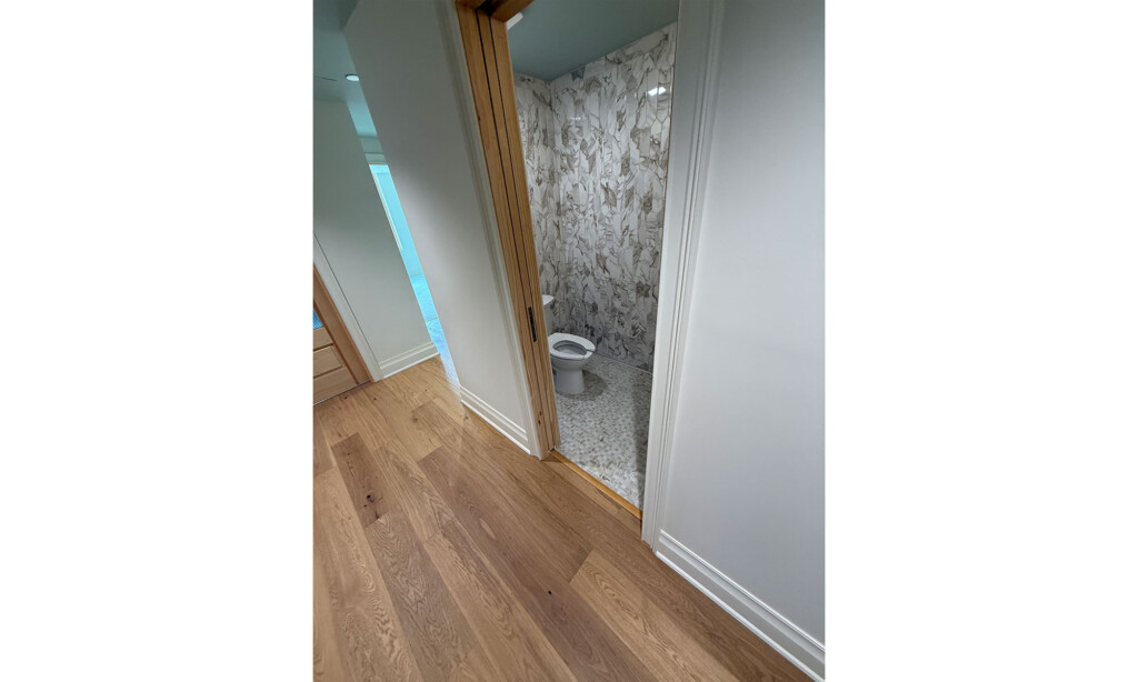 Restroom doorway at Winyah Dental Group with wood-look flooring and marble-look wall tile