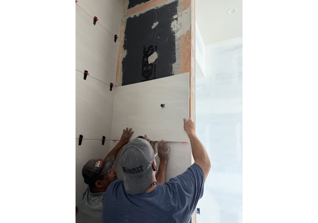 J&S Flooring installer setting large-format shower wall tile at Woodward Project in Georgetown, SC