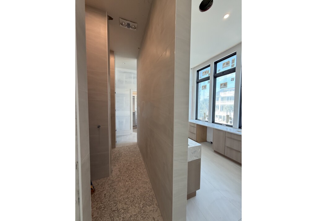 Woodward Project primary bathroom hallway with large windows and vanity