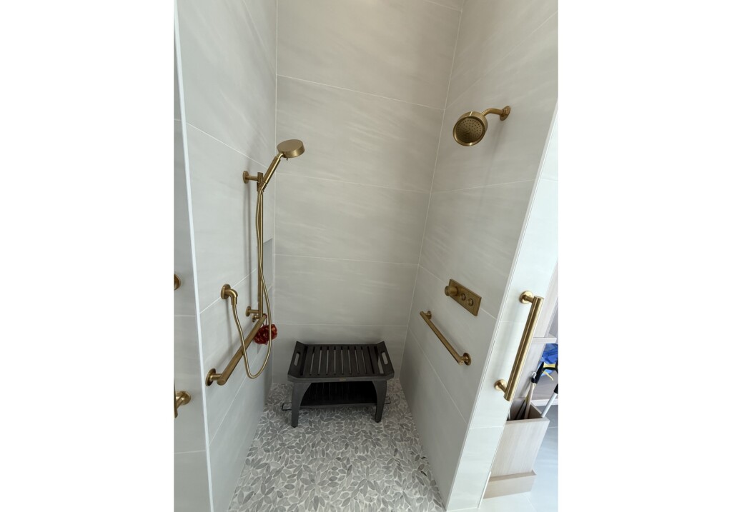 Woodward Project accessible shower with brass grab bars, bench and large-format tile