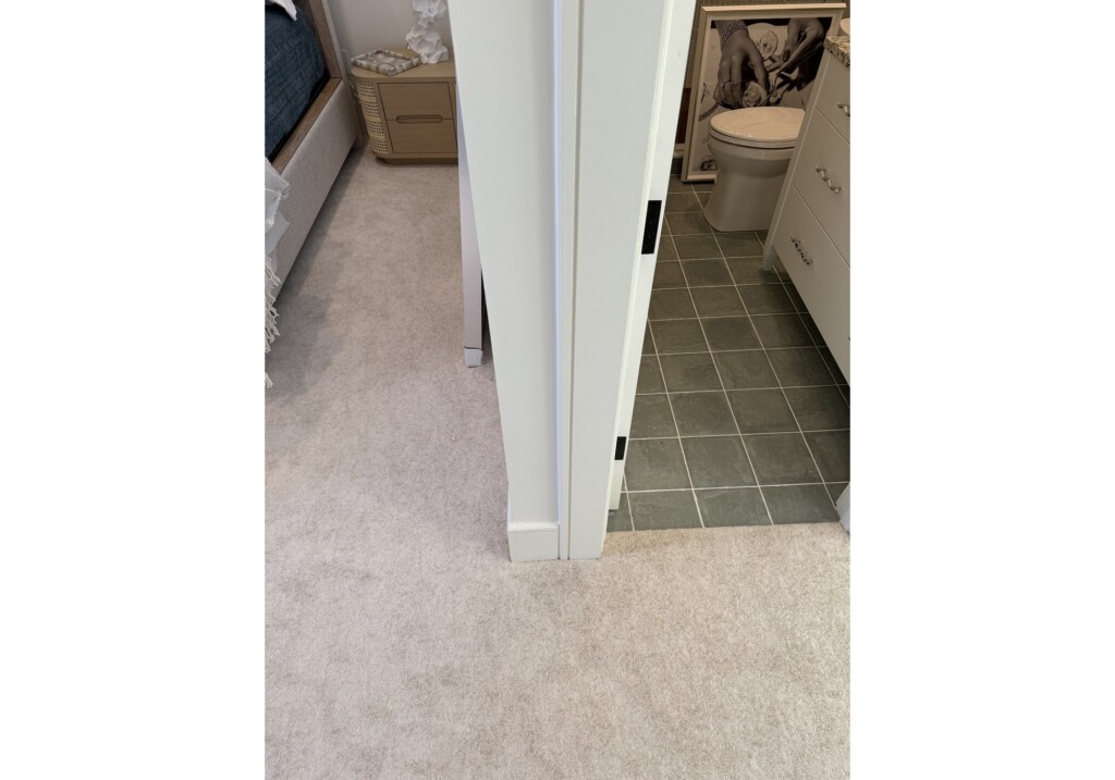 Woodward Project hallway with neutral carpet and gray-green tile bathroom floor