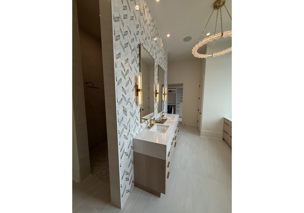 Woodward Project bathroom vanity with patterned wall tile and gold sconces