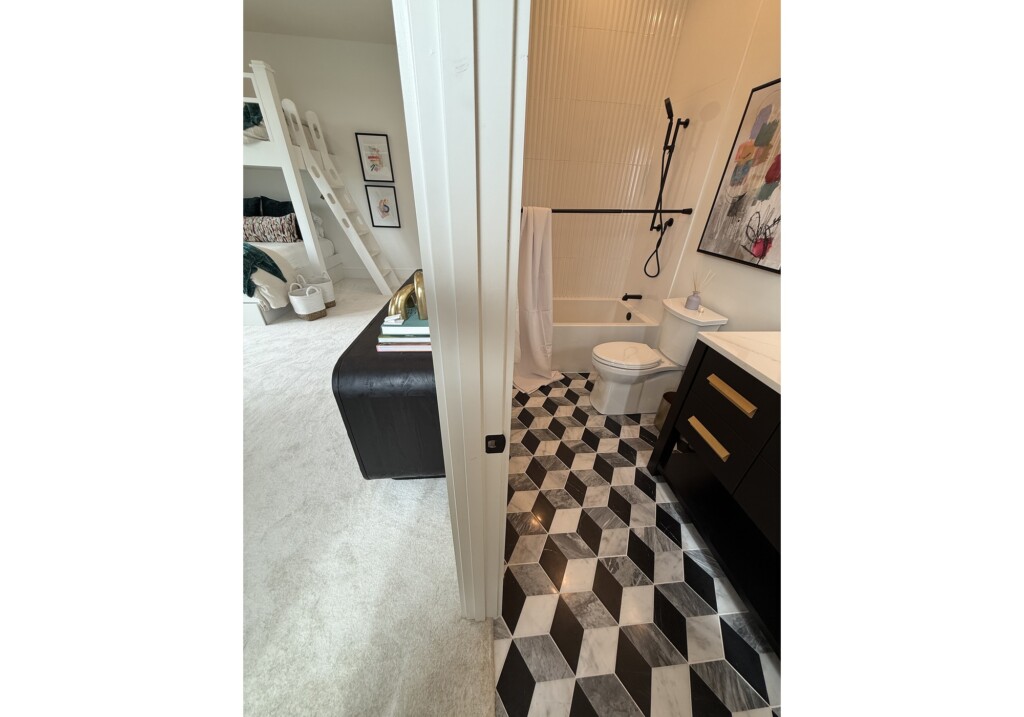 Woodward Project bathroom with black-and-white cube-pattern floor tile and navy vanity