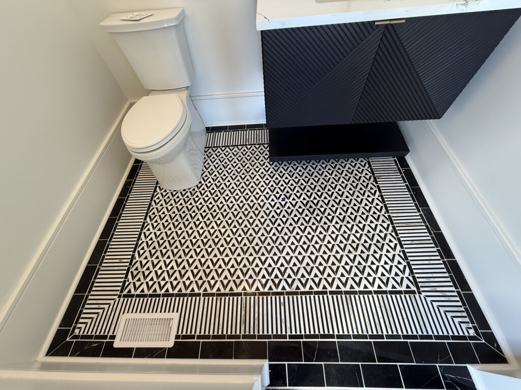 Woodward Project bathroom with black-and-white patterned mosaic floor tile and toilet