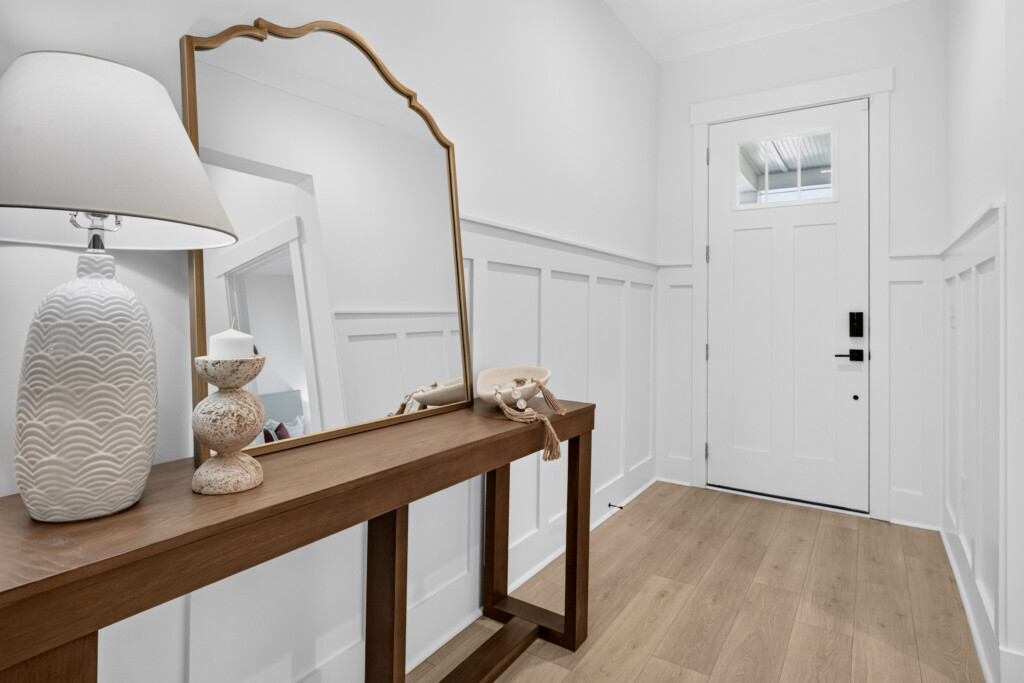 Sanderling Bay entryway with console table, wainscoting and light wood-look plank flooring