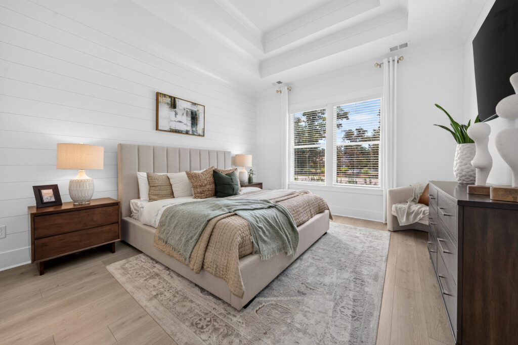 Sanderling Bay primary bedroom with area rug over light wood-look plank flooring