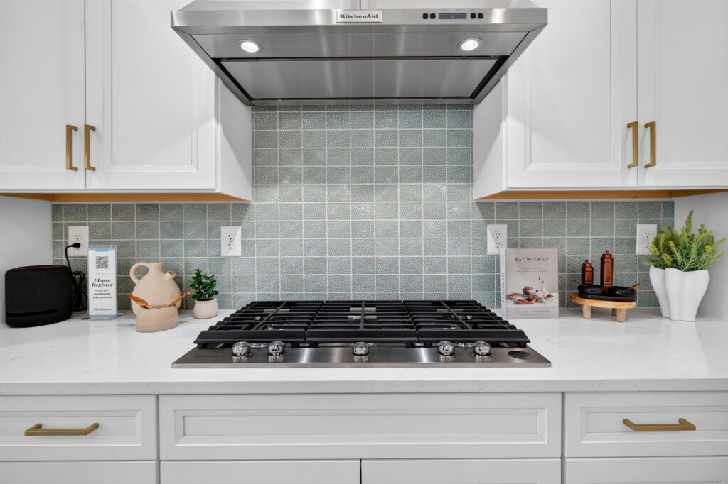 Gas cooktop with green square tile backsplash