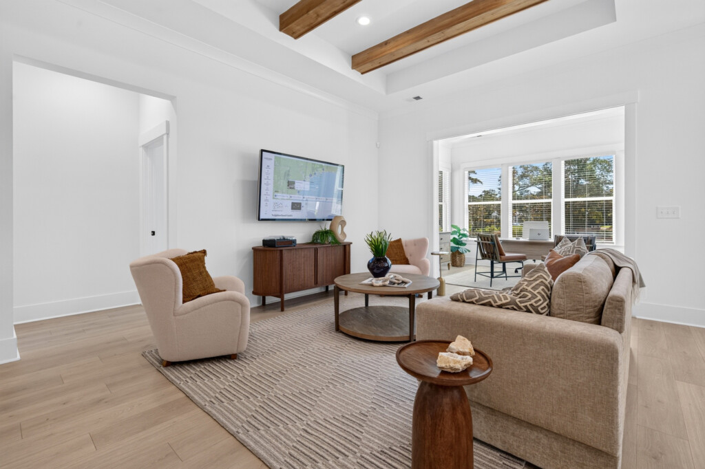 Living room opening to a sunroom with light wood-look plank flooring