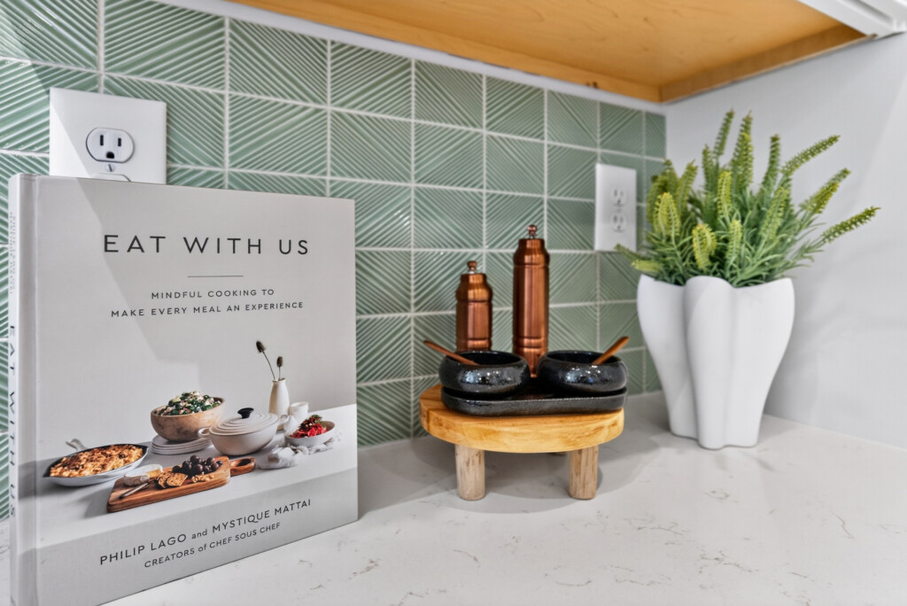 Sanderling Bay kitchen with green glossy tile backsplash, copper accents and cookbook