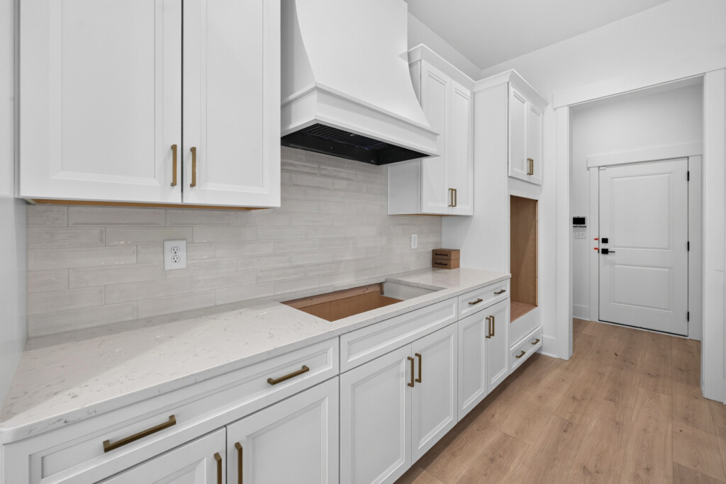Kitchen counter with tile backsplash and range hood