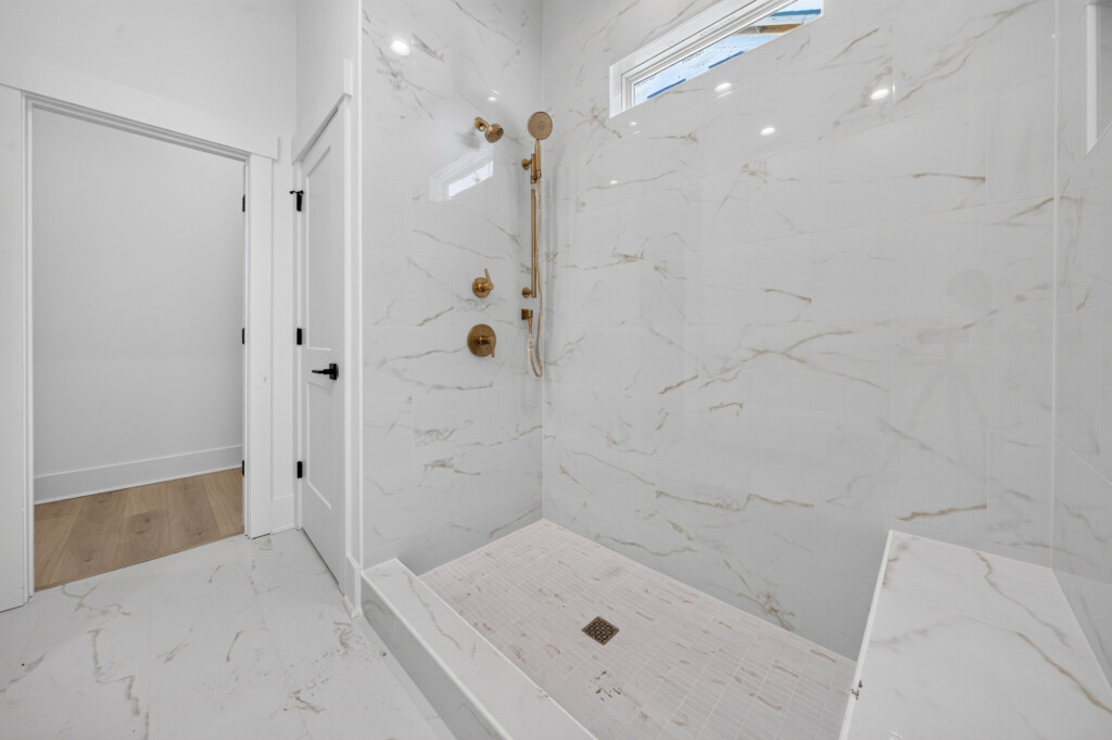 Walk-in shower with marble-look porcelain wall tile and mosaic floor, tile by J&S Flooring in Georgetown, SC