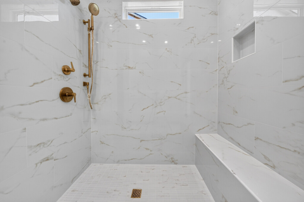 Walk-in shower with built-in bench and marble-look porcelain tile