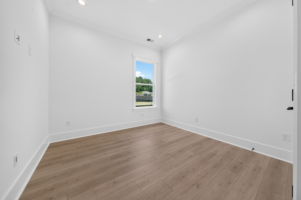 Empty room with light wood-look plank flooring and window