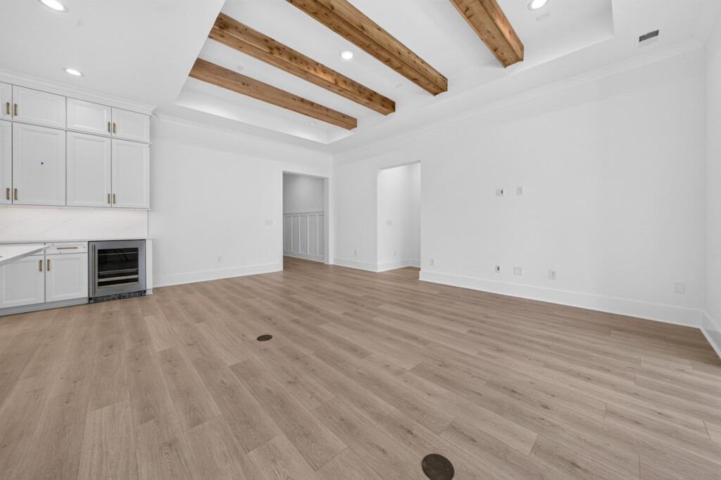 Living area with wood beams and light wood-look plank flooring