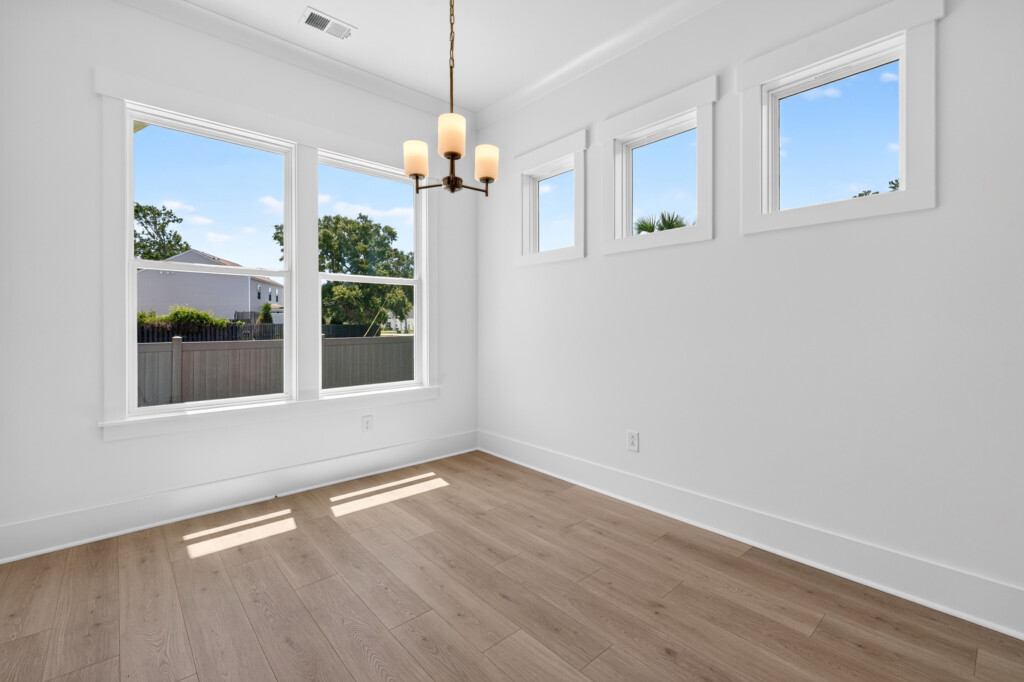 Dining nook with chandelier and light wood-look plank flooring